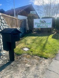 a blue mailbox in a yard with a sign at Pinewood Motels in Fairlie