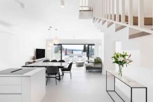 ein weißes Wohnzimmer mit Tisch und Stühlen in der Unterkunft Holiday home in Dramalj 45043 in Dramalj