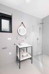 ein weißes Badezimmer mit Waschbecken und Spiegel in der Unterkunft Holiday home in Dramalj 45043 in Dramalj
