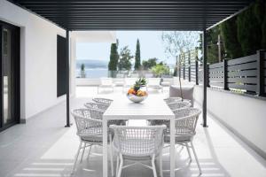 Ein weißer Tisch und Stühle mit einer Obstschale auf einer Terrasse in der Unterkunft Holiday home in Dramalj 45043 in Dramalj