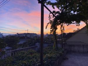 Una vista de una puesta de sol desde una casa con un poste en Small Hill Guesthouse, en Podgorica