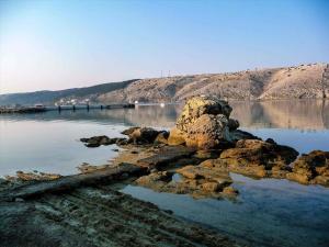 a large body of water with rocks in the water at Apartments in Lopar - Insel Rab 26467 in Lopar