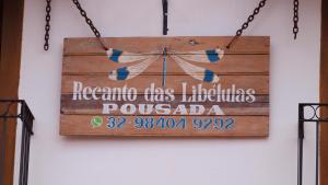 a sign on a wall that reads puyallup usa puyaled at Recanto das Libélulas Pousada in Tiradentes
