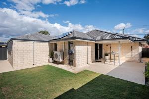 a house with a lawn in front of it at Modern Bassendean Abode in Perth