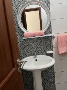 a bathroom with a sink and a mirror at une chambre dépaysante in Tarrafal