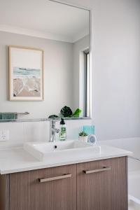 a bathroom with a sink and a mirror at Modern Bassendean Abode in Perth +18 photos