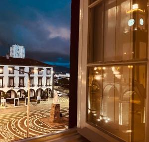 a view from a window of a street at night at AP Piso 2 inteiro · Portas Residence, o mais central de Ponta Delgada! in Ponta Delgada
