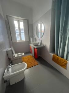 a bathroom with a toilet and a sink and a mirror at AP Piso 2 inteiro · Portas Residence, o mais central de Ponta Delgada! in Ponta Delgada +42 photos