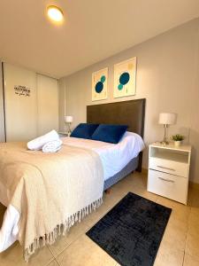 a bedroom with a large bed with blue pillows at Paramont Rosario 3 in Rosario de la Frontera +21 photos