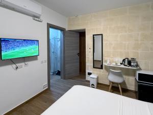 een kamer met een bed en een tv aan de muur bij Mini Studios in Central Victoria in Victoria