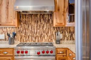 a stove top in a kitchen with wooden cabinets at Stevens Point Getaway - HUGE 5 bedroom Home 3 Full Bath in Stevens Point