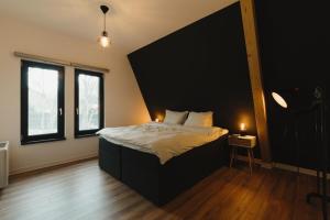 a bedroom with a large bed and two windows at Domaine A Chalet in Malu Roşu