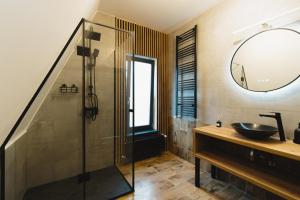 a bathroom with a sink and a glass shower at Domaine A Chalet in Malu Roşu +27 photos