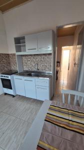 a kitchen with white cabinets and a sink at Apartamento pequeno central in Santa Vitória do Palmar