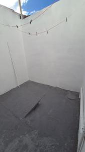 a room with a white wall and a concrete floor at Apartamento pequeno central in Santa Vitória do Palmar