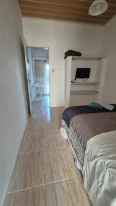 a bedroom with a bed and a wooden floor at Apartamento pequeno central in Santa Vitória do Palmar