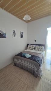 a bedroom with a bed in a white room at Apartamento pequeno central in Santa Vitória do Palmar
