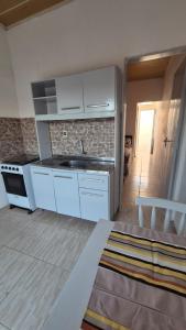 a kitchen with white cabinets and a sink in a room at Apartamento pequeno central in Santa Vitória do Palmar
