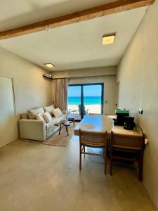 a living room with a table and a couch at BeachFront with Jacuzzi Bahía Turquesa in La Ventana