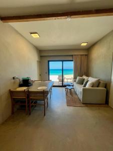 a living room with a table and a couch at Beachfront Luxury Condo Private Jacuzzi Ocean Views in La Ventana +105 photos