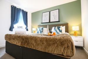 Un dormitorio con una cama grande con cortinas azules. en Stylish 2 Bedroom Duplex Apartment - Close to City Centre - Balcony, Free Parking, Self-Check-In, Fast Wifi & Smart TVs by Yoko Property, en Milton Keynes