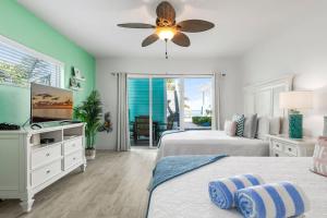 ein Schlafzimmer mit zwei Betten und einem Deckenventilator in der Unterkunft The Turtle Nest at Cottages in Sand Bluff