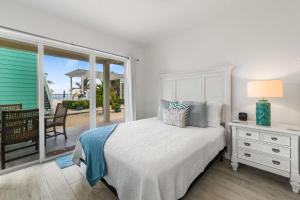 ein Schlafzimmer mit einem Bett und einem Balkon mit Meerblick in der Unterkunft The Turtle Nest at Cottages in Sand Bluff