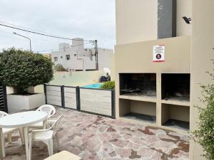 een terras met een tafel en stoelen en een zwembad bij Bahia creek in Las Grutas