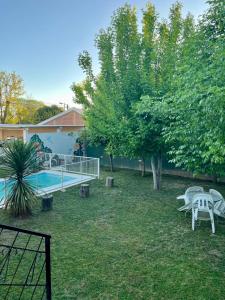 einen Garten mit einem Pool, Stühlen und einem Baum in der Unterkunft Luna Vallista House in Mina Clavero