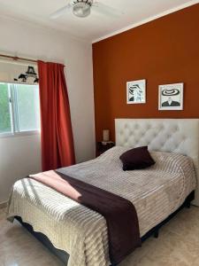 ein Schlafzimmer mit einem großen Bett mit einer roten Wand in der Unterkunft Luna Vallista House in Mina Clavero + 5 Fotos