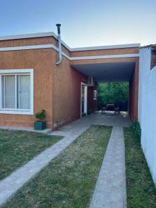 Ein Backsteinhaus mit einem Gehweg, der in einen Hof führt in der Unterkunft Luna Vallista House in Mina Clavero
