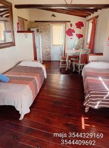 a bedroom with two beds and a dining room at Suite's on the rock's in Nono +30 photos