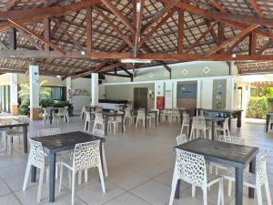 Un comedor con mesas y sillas en un edificio. en Cobertura Duplex - Luxo com Jacuzzi e 3 Suítes, en Aquiraz