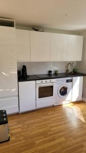 Una cocina con gabinetes blancos y lavadora. en Nice 65m2 apartment in central Dachau, en Dachau