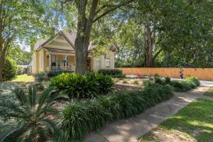 ハッティーズバーグにあるSpacious, Soulful Southern Stayの庭木のある黄色い家