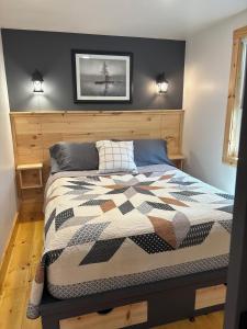 a bedroom with a bed with a quilt on it at Camptown Cabin in Eagle Rock