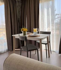 コラ・ディ・ラツィーゼにあるMobilehome in Lazise - Gardasee 45718の椅子2脚と花のテーブル +10枚の写真