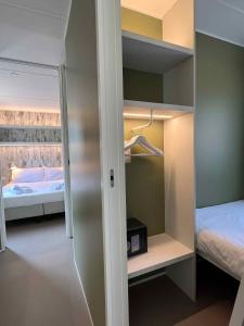 コラ・ディ・ラツィーゼにあるMobilehome in Lazise - Gardasee 45718のベッドルーム(ベッド1台、クローゼット付)が備わる小さな客室です。