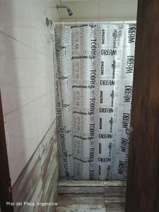 a shower curtain with writing on it in a bathroom at La perla del mar in Mar del Plata