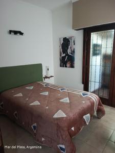 a bedroom with a bed with a quilt on it at La perla del mar in Mar del Plata +4 photos