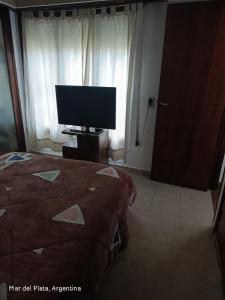 a bedroom with a bed and a tv in a room at La perla del mar in Mar del Plata