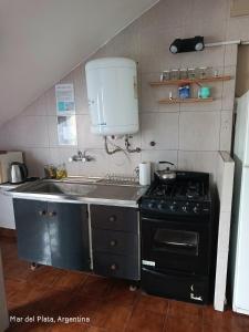 a small kitchen with a stove and a sink at La perla del mar in Mar del Plata