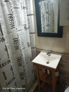 a bathroom with a sink and a shower curtain at La perla del mar in Mar del Plata