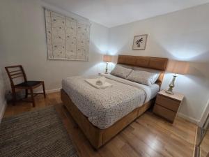 a small bedroom with a bed and a chair at Central Two Bedroom Apartment Near Union Square -Free Parking in Aberdeen