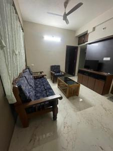 a living room with a bed and a couch at Yashaswi Residency - G001 in Manipala