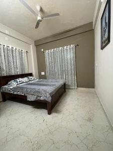 a bedroom with a bed and a ceiling fan at Yashaswi Residency - G001 in Manipala