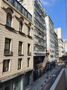 a tall building on a city street with buildings at Hostel Downtown Las Morenas in Buenos Aires