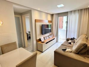 ein Wohnzimmer mit Sofa und Fernseher in der Unterkunft Avenida Tuslan in Mamanguape