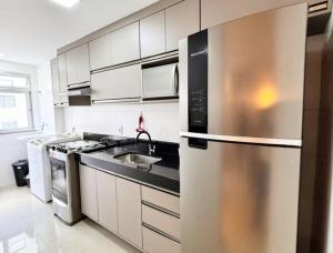 eine Küche mit einer Spüle und einem Kühlschrank aus Edelstahl in der Unterkunft Avenida Tuslan in Mamanguape