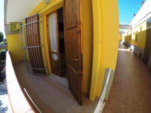 een geel gebouw met een houten deur en een gang bij Apartment in Rosolina Mare 34551 in Rosolina Mare +2 foto's